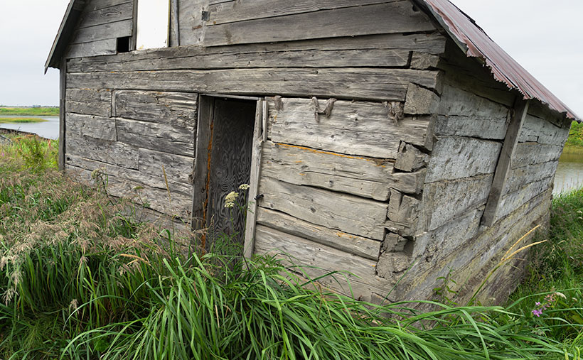 An abandoned shack sits empty by the bay in Ninilchick, Alaska.