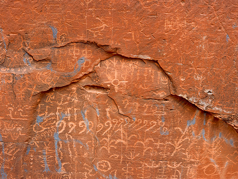 North of Cameron Arizona, on the Navajo Reservation near Ceadar Ridge, are large sandstone these rocks with pictographs on the. An unknown modern vandal has spray painted blue marks over them.