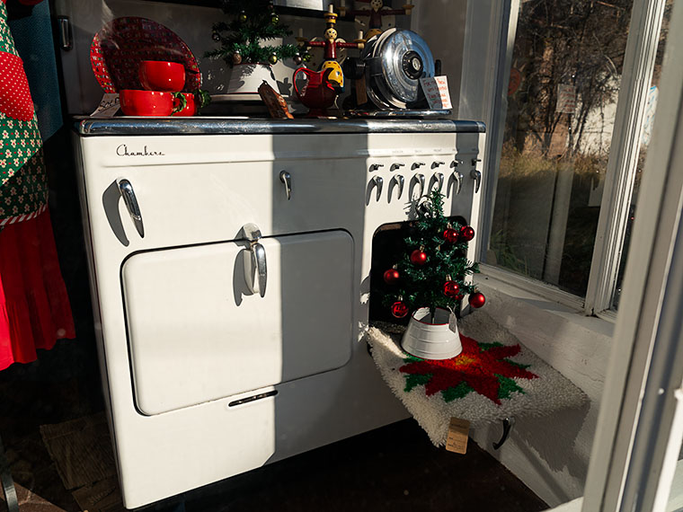 A festive window display showcasing a vintage Chambers gas stove and Christmas decorations.