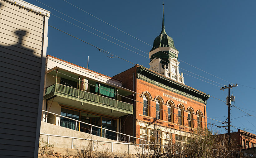 Bisbee's Pythian Castle: A Clock Tower of History - The green and white clock tower on the red-brick building pierces the cold blue winter sky.