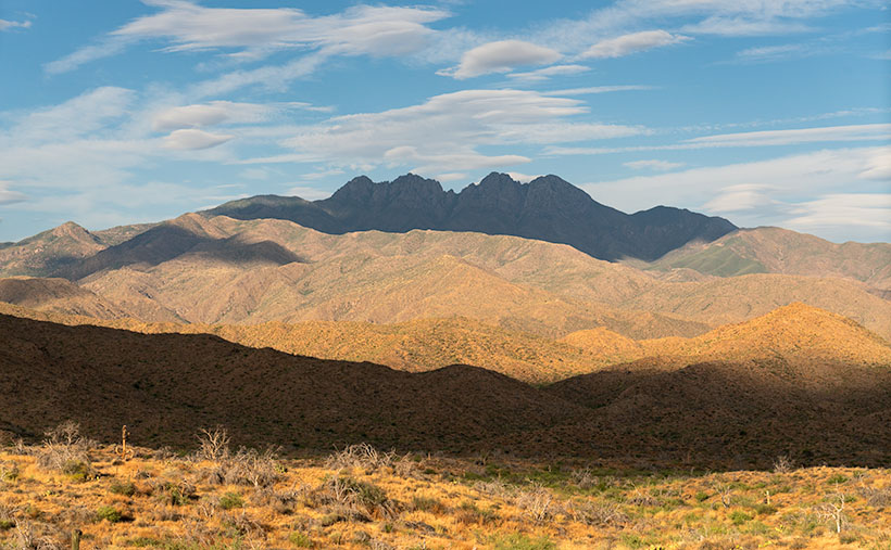 Four Peaks in the Mazatzal Mountains: Majestic mountain range against a backdrop of lenticular clouds and blue sky.