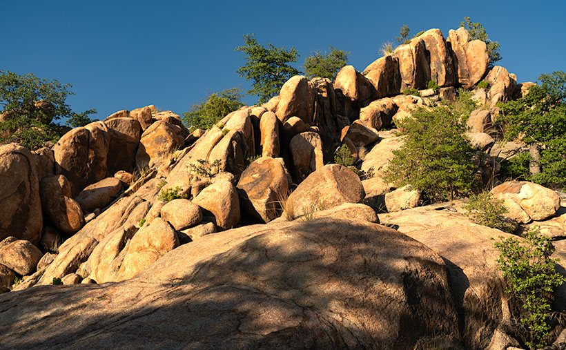 A golden stairway of rock formations ascending to a blue sky in the Granite Dells during sunset.