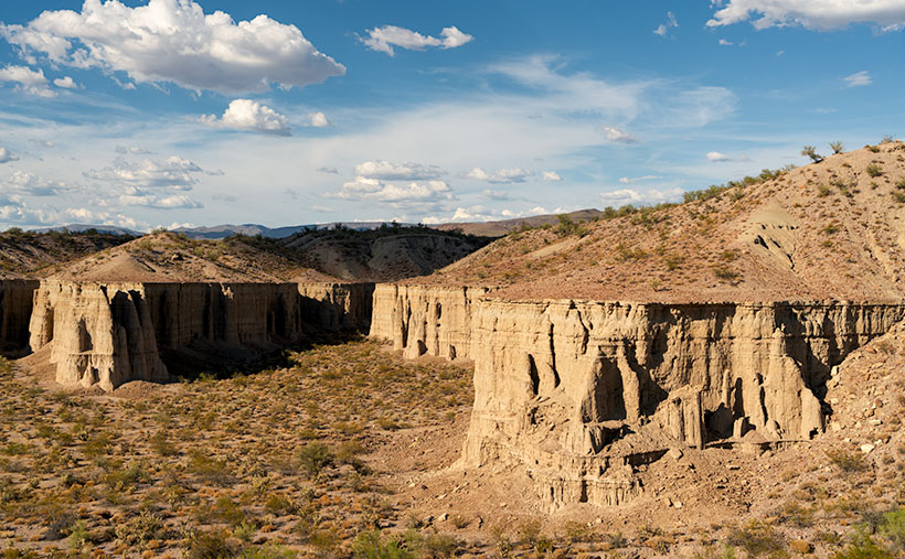 Two sedimentary cliff prominence eroded to form preliminary hoodoos, captured during the golden hour near Big Sandy River, Arizona.