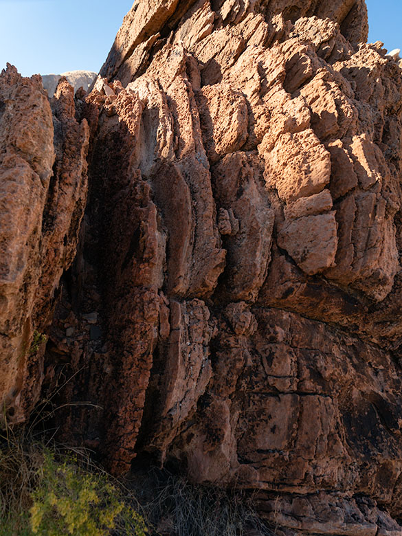 Brown layered Navajo Sandstone uplifted and eroded by fault activity in Whitney Pocket, with unusual rounded edges and color variation.