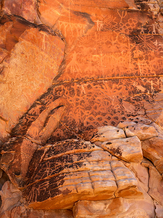 Intricate Fremont People petroglyphs on a high cliff face at Whitney Pocket, challenging understanding of their creation.