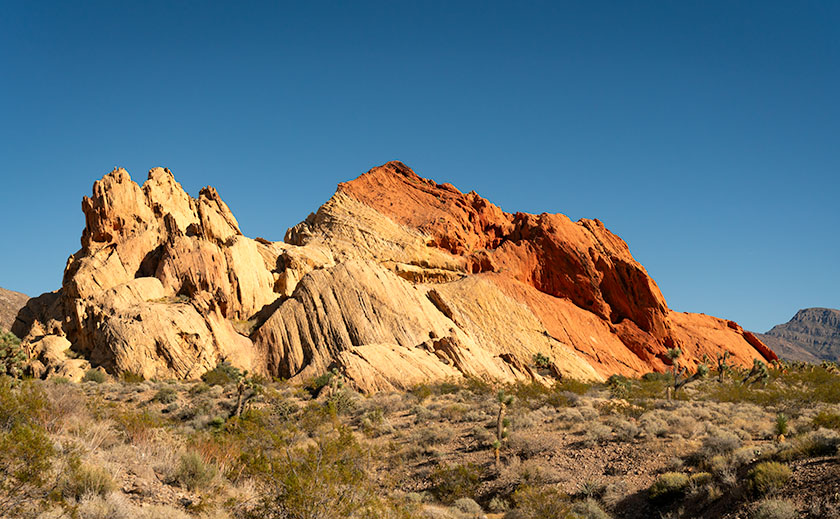 A butte in Whitney Pocket with layered Navajo and Entrada sandstone, with the red end facing south, creating a 'Neapolitan ice cream' effect in the desert.