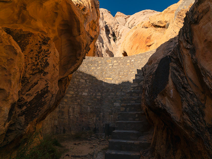 WPA-built stone dam between rock formations in Gold Butte National Monument, captured by Jim Witkowski.