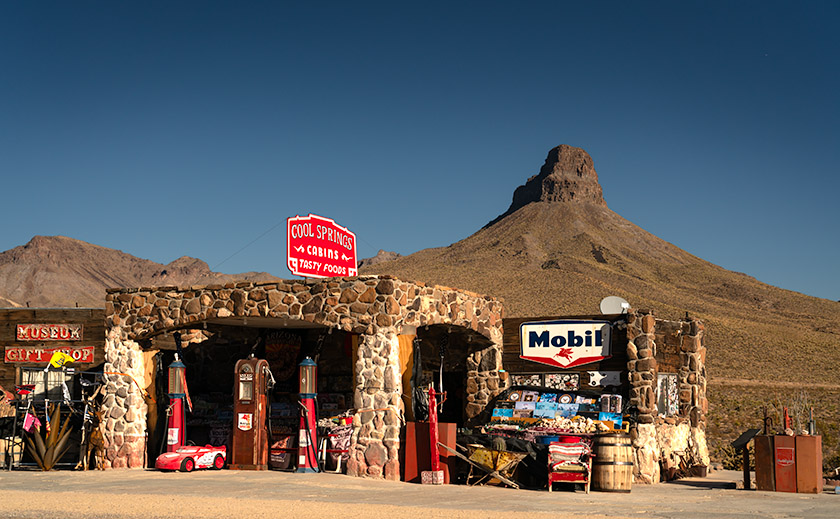 Cool Springs Station and vintage gas pumps along Route 66 with Thimble Mountain in the background in Oatman, Arizona.