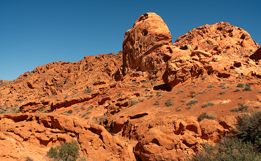 Red sandstone rock formation known as Red Turret amid desert shrubs in Valley of Fire State Park