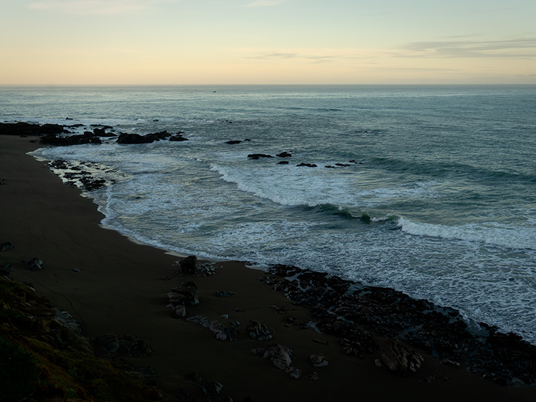 Early morning view looking south over Moonstone Beach in Cambria, California, with waves breaking gently on a rocky shoreline