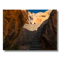 WPA-built stone dam between rock formations in Gold Butte National Monument, captured by Jim Witkowski.