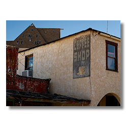 Weathered coffee shop sign on the side of a historic hotel in Oatman, Arizona.