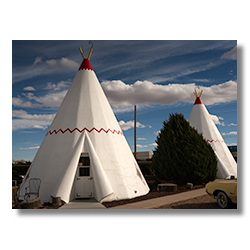 White tee pee-shaped motel rooms with classic car parked outside on Route 66 in Holbrook, Arizona
