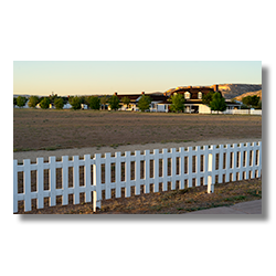 The parade grounds at Camp Verde are surrounded by a white picket fence and they are the 
								 commanding officer's back yard.