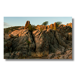 A subtle sunrise over the Granite Dells in Prescott, Arizona, highlighting lichen-covered rocks resembling toes and victory signs..