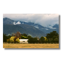 A farm shed in Kaikoura below the cloud covered Seaward Kaikoura Range.